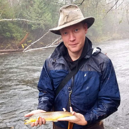 HAS instructor in a river holding a fish.