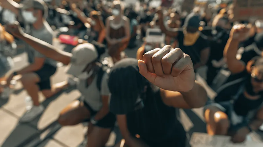 Group of people kneeling together with fists raised