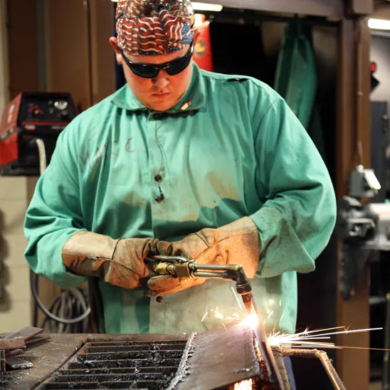 Student welding in the lab at Mid