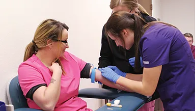 Phlebotomy students train in class